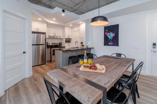 a kitchen and dining room with a wooden table and chairs at 2 Bedroom condo - 800M of Old Quebec ! in Quebec City