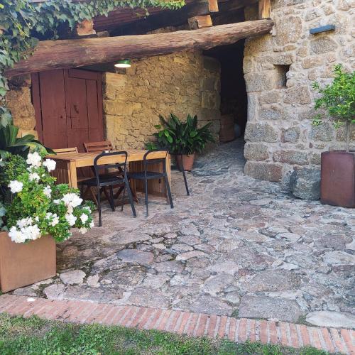 a stone patio with a wooden table and chairs at Zocailla in Gata