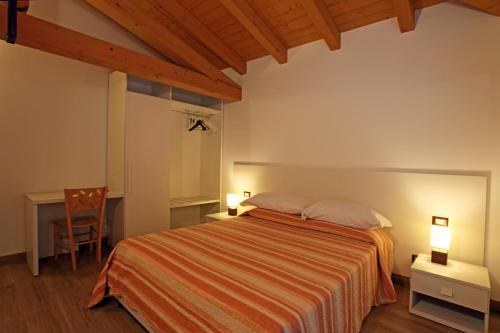 Nimis的住宿－Al Posto Giusto，一间卧室配有一张床、一张桌子和一把椅子