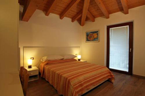 1 dormitorio con 1 cama, 1 ventana y 2 lámparas en Al Posto Giusto, en Nimis