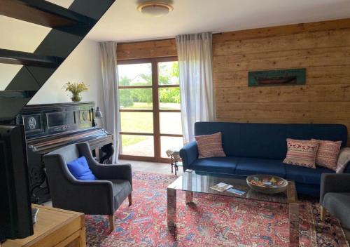 a living room with a blue couch and a fireplace at Dom wakacyjny Poniatówka in Dąbrowa