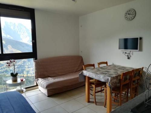 uma sala de estar com um sofá e uma mesa em Appartement au pied des pistes em Saint-Lary-Soulan