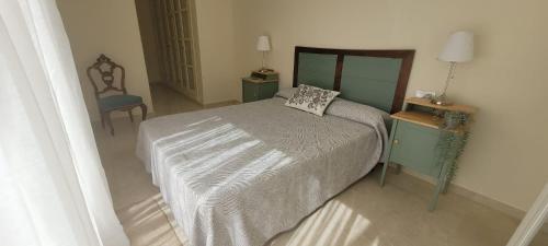 1 dormitorio con 1 cama grande y 1 silla en LUMINOSO APARTAMENTO San Roque Golf Club, en San Roque