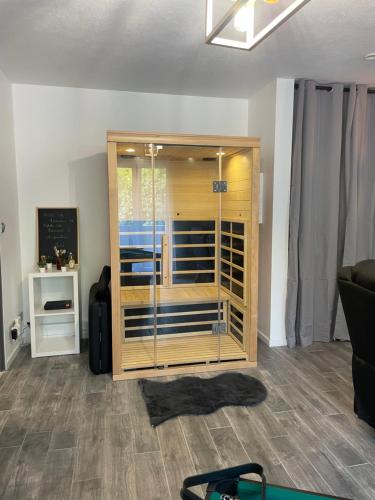 a room with a wooden cabinet with a glass door at T2 rénové, jaccuzi, sauna, sièges massants, jardin, parking, métro in Toulouse