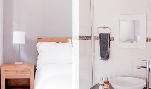 a white bedroom with a bed and a sink at Warm Karoo in Bloemfontein