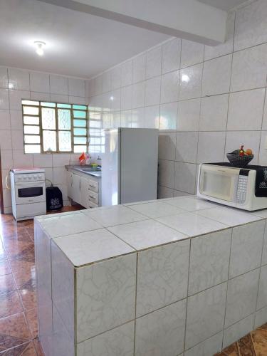 a kitchen with a counter with a microwave and refrigerator at Triunfo Flat in Triunfo