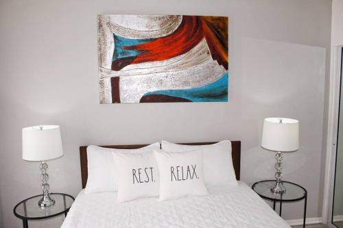 a bedroom with a bed with a painting on the wall at Millie's Paradise - Bay Beach Ocho Rios in Ocho Rios