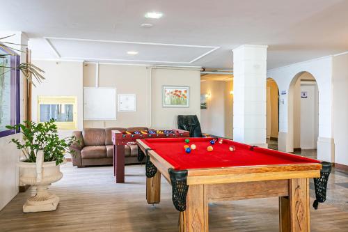 a living room with a red pool table at Ingleses Palace Hotel in Florianópolis