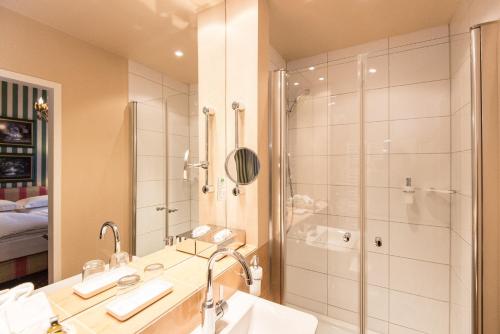 a bathroom with a shower and a sink at Hotel City House in Hamburg