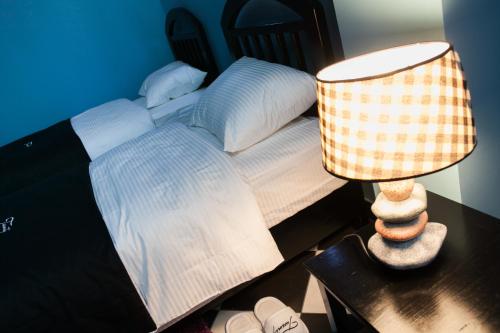 a bedroom with a bed and a lamp on a table at Bed & Breakfast Twenty in Kikinda