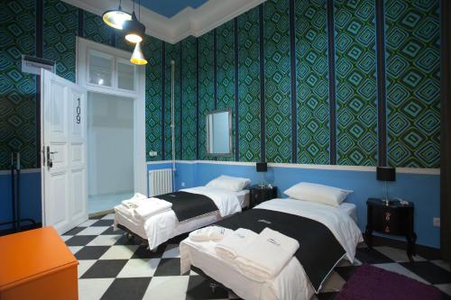 two beds in a room with blue and green wallpaper at Bed & Breakfast Twenty in Kikinda