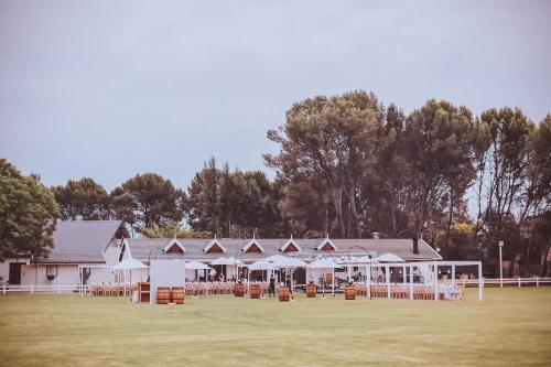 a group of white buildings with tables and umbrellas at Warm Karoo in Bloemfontein