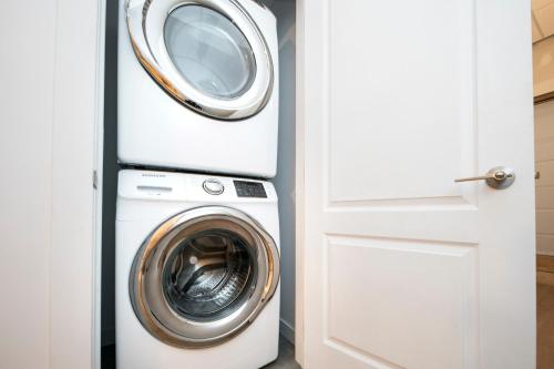 a washing machine and a washer and dryer next to a door at HoMa Homestay Hotel by Olympic Stadium Montreal Auberge-Hostel in Montréal