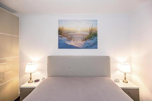 ein Schlafzimmer mit einem Bett und zwei Lampen in der Unterkunft Villa Deichgraf 12 "Meerblick" in Börgerende-Rethwisch