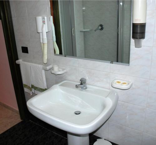 a white sink in a bathroom with a mirror at Hotel Grillo Verde in Torre Annunziata