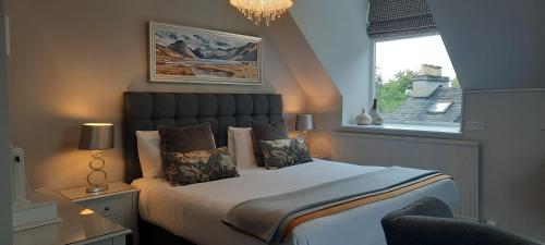 Un dormitorio con una cama grande y una ventana en Rocklea Guest House, en Windermere