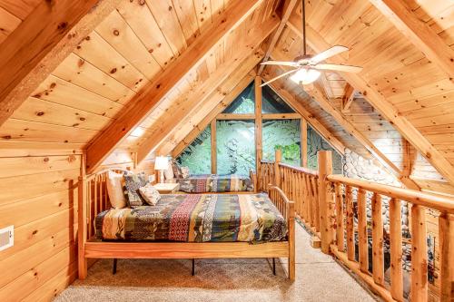 a bedroom in a log cabin with a bed and a ceiling fan at Bear Pleasures in Gatlinburg