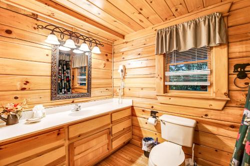 a log cabin bathroom with a sink and a toilet at Bear Pleasures in Gatlinburg