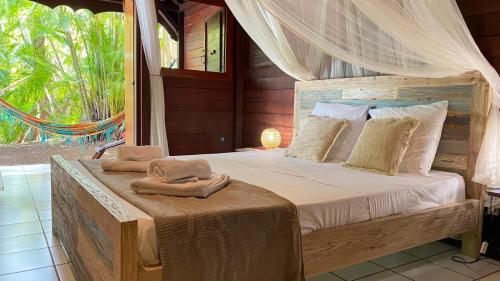 1 dormitorio con 1 cama con toallas en GWO CAILLOU - Gites créoles de charme, en Bouillante