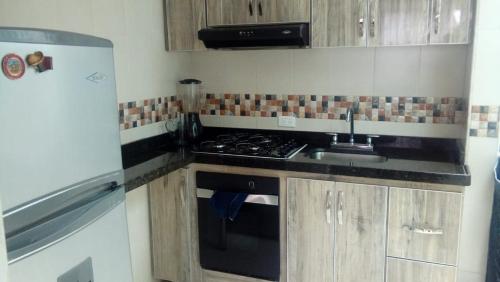 een keuken met een fornuis, een wastafel en een koelkast bij HABITACION EN SUBA in Bogota