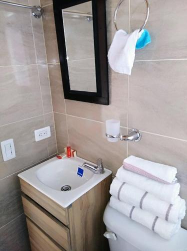 een badkamer met een wastafel en een toilet met handdoeken bij HABITACION EN SUBA in Bogota