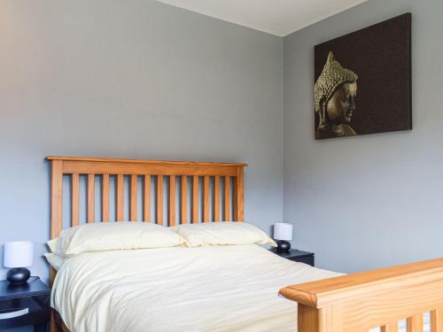 a bedroom with a bed with a picture on the wall at Rhiw Gam in Abbey-Cwmhir