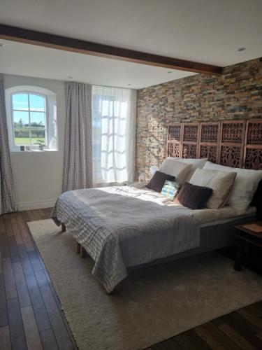 een slaapkamer met een groot bed met een bakstenen muur bij Birkelund BnB in Otterup