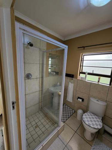 a bathroom with a shower and a toilet and a sink at Asher's Place in East London