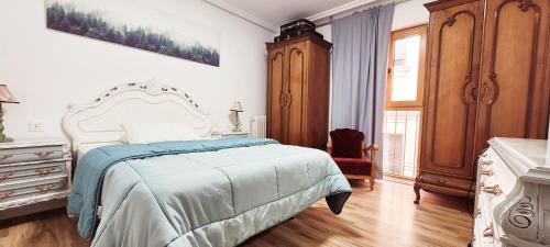 a bedroom with a bed and a dresser and a window at www SanMartinPlaza es En el corazón del casco histórico in León
