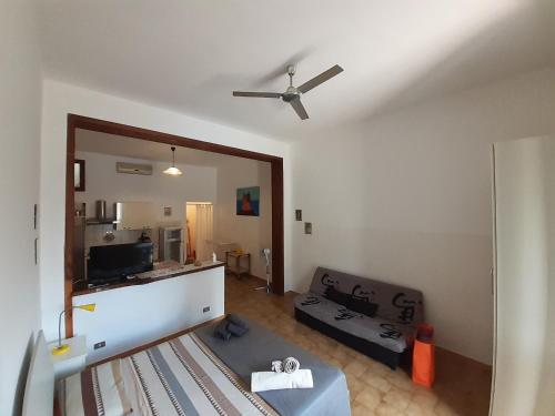 Una sala de estar con un sofá y un ventilador de techo. en Lido dei Miracoli, en Lido Conchiglia