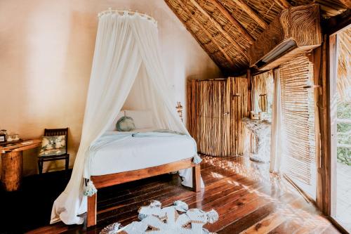 - une chambre avec un lit et une moustiquaire dans l'établissement Azulik, à Tulum