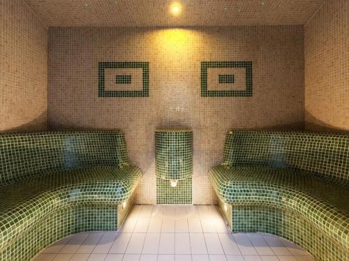 a room with two beds and a tiled wall at Holiday Home in Ustronie Morskie near Beach in Ustronie Morskie