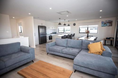 uma sala de estar com dois sofás e uma cozinha em Loch Ard Place em Peterborough