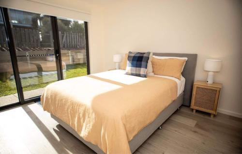 um quarto com uma cama grande e uma janela grande em Loch Ard Place em Peterborough