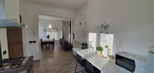 a kitchen and living room with a table in the background at Da Nonno Bruno - Luminoso appartamento Relax - Self Check-in in Pratovecchio