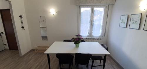 a white table with chairs and a vase of flowers on it at Da Nonno Bruno - Luminoso appartamento Relax - Self Check-in in Pratovecchio