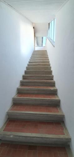 a staircase in a white building with a stair case at Da Nonno Bruno - Luminoso appartamento Relax - Self Check-in in Pratovecchio