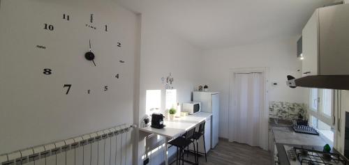a kitchen with a counter and a clock on the wall at Da Nonno Bruno - Luminoso appartamento Relax - Self Check-in in Pratovecchio