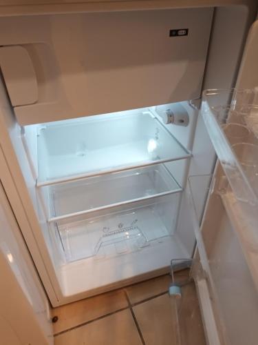 un réfrigérateur vide avec sa porte ouverte dans une cuisine dans l'établissement Gorgeous place, center Paris ,close to Louvre Meusm and Eiffel Tour, à Paris