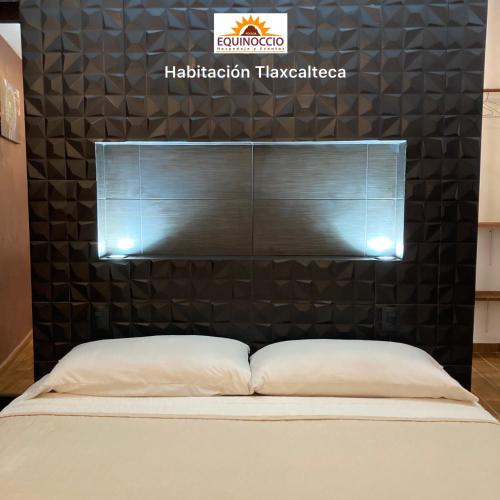 a bed in a room with a black wall at Posada Equinoccio in Bernal