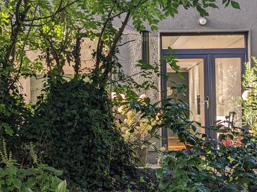 a front door of a house with a tree at Spacious Contemporary Chalet type Apartment. in Galway