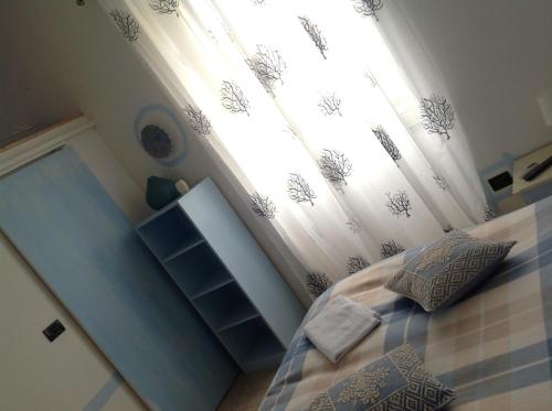 a bedroom with a bed and a window with curtains at B&B Cheap Holidays in Sorso