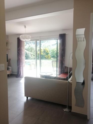 a living room with a couch and a large window at Superbe T3, havre de paix, entre plage et village in Capbreton