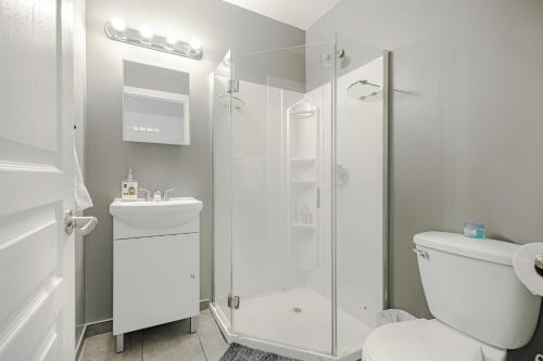 een badkamer met een douche, een toilet en een wastafel bij HoMa Homestay Hostal by Olympic Stadium! in Montreal