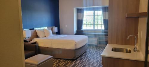 a hotel room with a bed and a sink at Microtel Inn & Suites by Wyndham Fountain Fort Carson in Fountain
