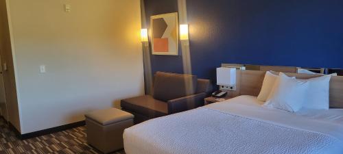 a hotel room with a bed and a chair at Microtel Inn & Suites by Wyndham Fountain Fort Carson in Fountain