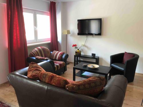 a living room with a couch and chairs and a tv at Potsdamer Platz-Top Spot Studio 1 in Berlin
