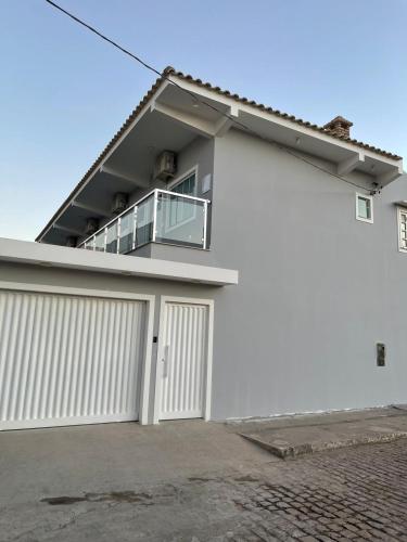 uma casa branca com uma garagem branca em Escalada Hospedagens e Eventos em Mucugê