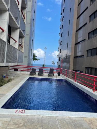 une piscine au milieu de deux bâtiments dans l'établissement Flat Recife - Boa Viagem, à Récife