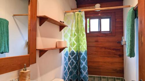 a bathroom with a shower curtain and a window at Wood Cabin - Cabana Maderas in Balgue